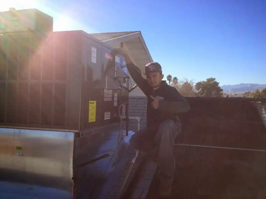 HVAC technician performing AC Tune-Up on a rooftop unit in Chesterfield